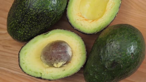 Avocado Halves With Nut Spinnin On Cutting Board 03