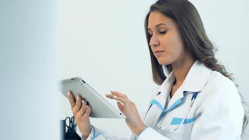 Female Doctor Using Tablet Computer in Medical Office