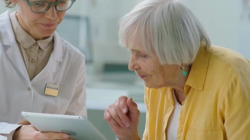 Woman Doctor Showing Tablet to Senior Patient