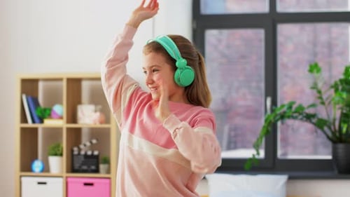 Happy Girl Dancing with Headphones in Bedroom