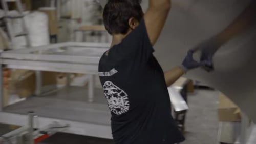 Worker places metal sheet on a table frame