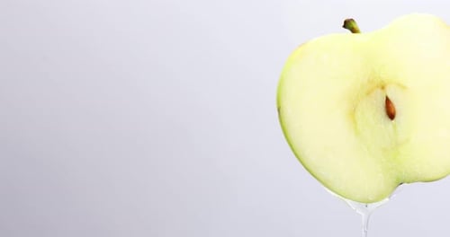 Apple juice dripping from fresh sliced green apple