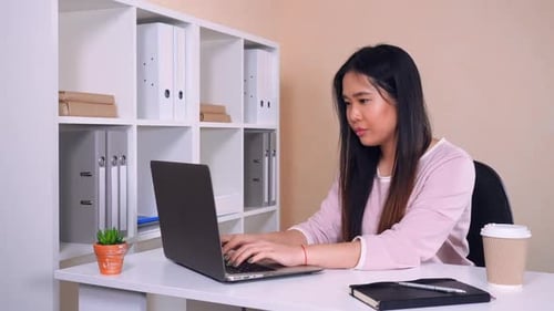 Asian Woman Focused at Work