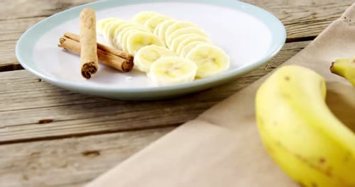 Sliced Bananas with Cinnamon Sticks on a Plate