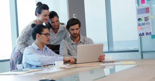 Colleagues Collaborating Around Laptop in Bright Modern Office