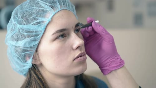 Woman Getting Eyebrow Tint in Beauty Clinic