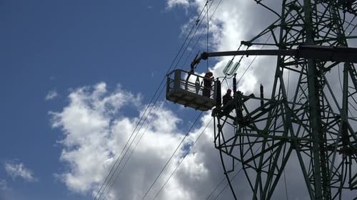 Electricians Repairing Power Lines on Transmission Tower
