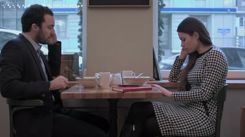 Businessman and Woman Communicate By Smartphones at Lunch in Cafe