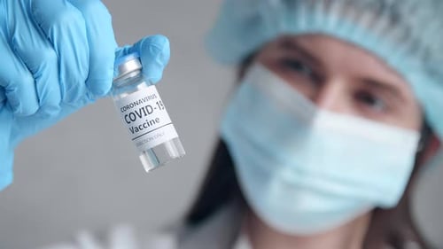 Closeup of a Woman Holding a Test Tube with a Vaccine