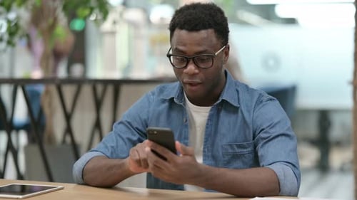 Young Adult Celebrating Success on Smartphone