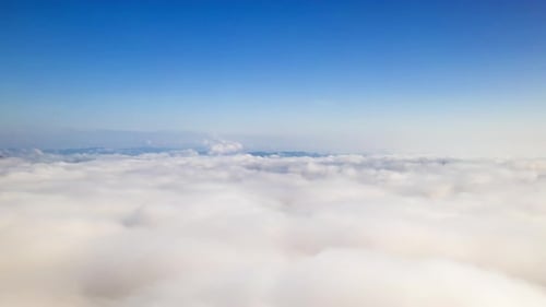 Aerial View Above Fluffy Clouds and Blue Sky
