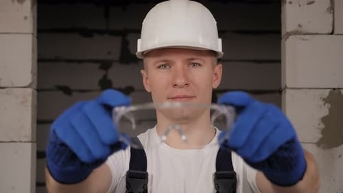 Construction Worker Holding Safety Glasses