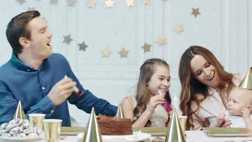 Family Celebrates Birthday Party with Cake and Fun