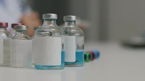 Close up covid 19 vaccine transparent liquid vials in the laboratory.