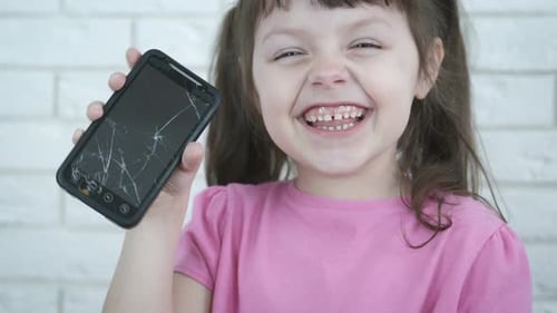 Girl Shows Cracked Smartphone Screen Indoors
