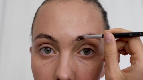 Closeup of Woman Doing Makeup of Eyebrows