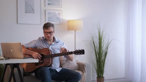 Man Playing Guitar and Teaching Online from Home