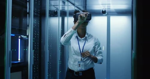 Technician Works in a Data Center Wearing a VR Headset