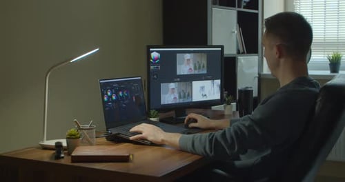 Man Working on Computer with Two Monitors Color Correction Post Production Video or Photo in