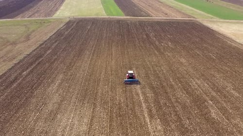 Tractor plowing field with aerial view