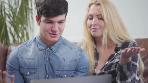 Adorable Couple Sitting in Front of a Laptop at Home