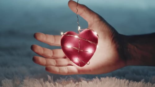 Hand Reaches For Heart with String Lights