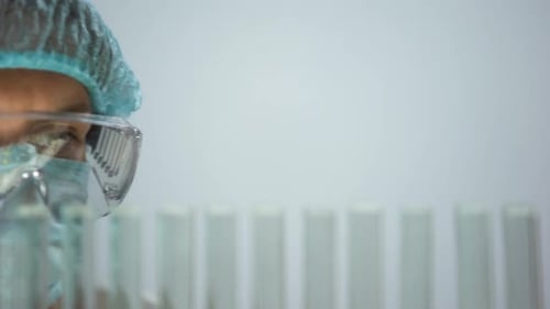 Chercheur prélevant un tube à essai avec échantillon d'essence, vérifiant la qualité
