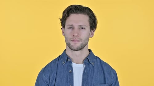 Young Adult Man Close-up Portrait on Yellow Background