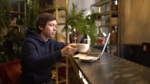 Man Working on a Aptop in Cafe