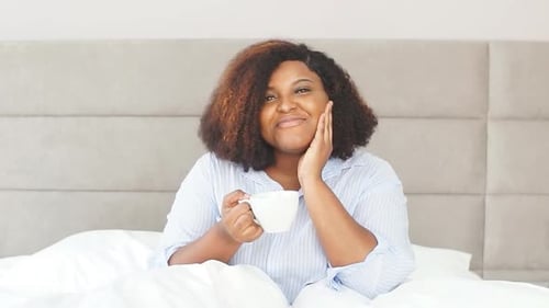 Cheerful Young Woman Drinking Coffee in a Luxury Hotel