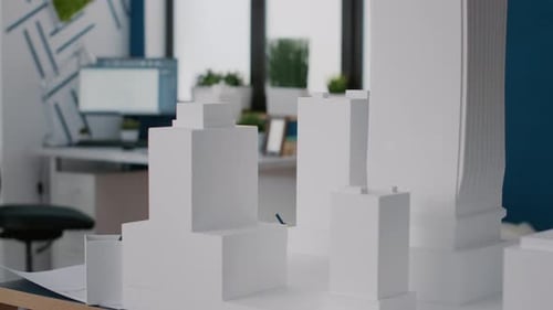 Nahaufnahme von Gebäudemodell und Maquette zum Entwurf des Bauplans auf dem Schreibtisch