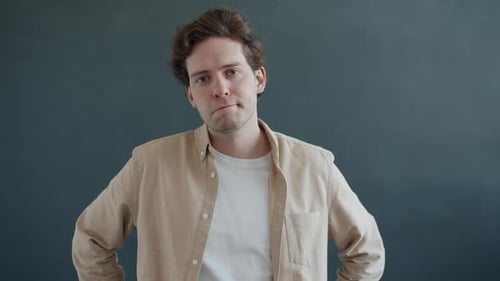 Thoughtful Young Adult Posing Against Gray Background
