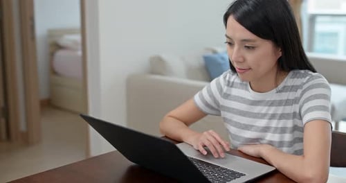 Woman Using Laptop Computer At Home