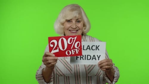Smiling Senior Woman Holds Black Friday Sale Signs