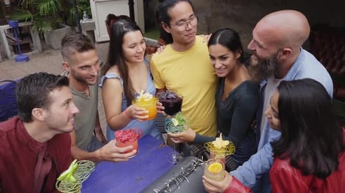 Happy Friends Drinking Cocktails and Laughing Together