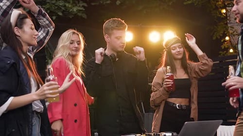 Friends Dancing at Outdoor Party with DJ at Night