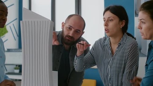 Close Up of Coworkers Analyzing Building Model and Maquette to Plan Construction Structure