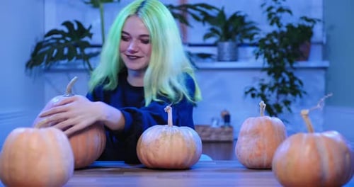 Girl Draws Funny Faces on Pumpkins