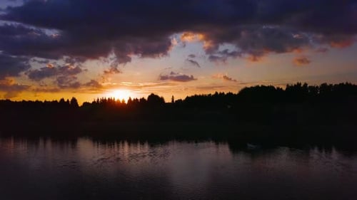 Fantastischer Sonnenuntergang an einem See. Wunderschöne Farben. Geschossen von einer Drohne, die tief über dem Wasser fliegt. Entspannt