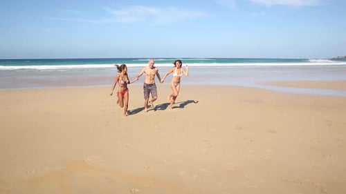 Multiracial group of friends running on the beach at seaside