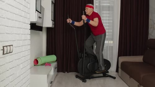 Active Senior Man Exercising on Elliptical at Home