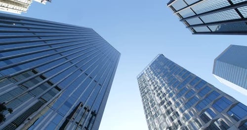 Upward View of Gleaming Skyscrapers Against Blue Sky