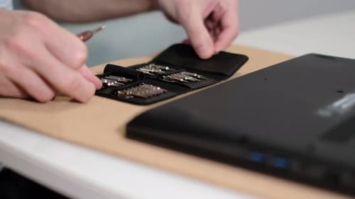 Hands Choose Screwdriver Tip to Repair Laptop