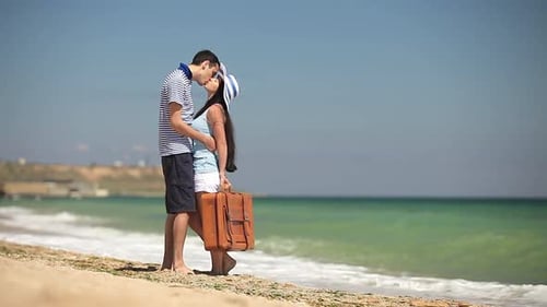 Young couple kissing on the beach by the sea