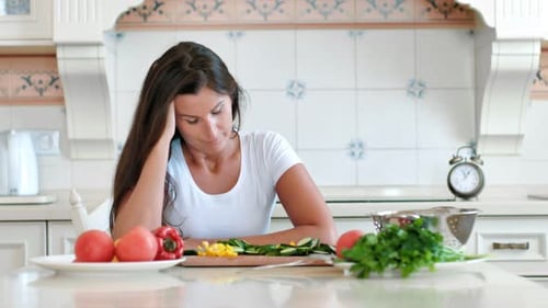 Woman at Table in Kitchen Looking Stressed
