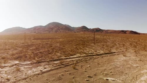 Aerial shots of the barren, sandy, rocky, mountain filled, Mojave Desert on a sunny day.