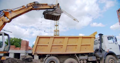 Excavator Loading Dump Truck at Construction Site