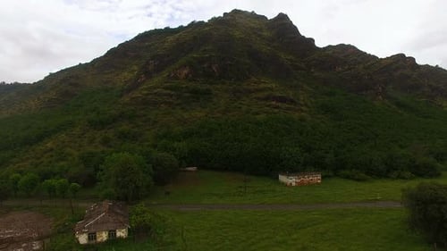 Aerial view of green hillside and rural area with old houses, environment