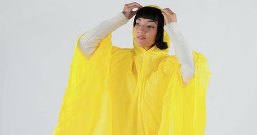Frau im gelben Regenmantel gestikuliert, um den Regen zu spüren 4K 4k
