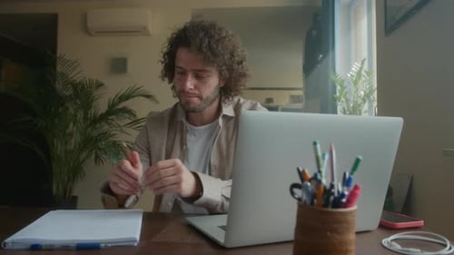 Professioneller kreativer Mann sitzt an seinem Schreibtisch im Home Office Studio und arbeitet an einem Laptop